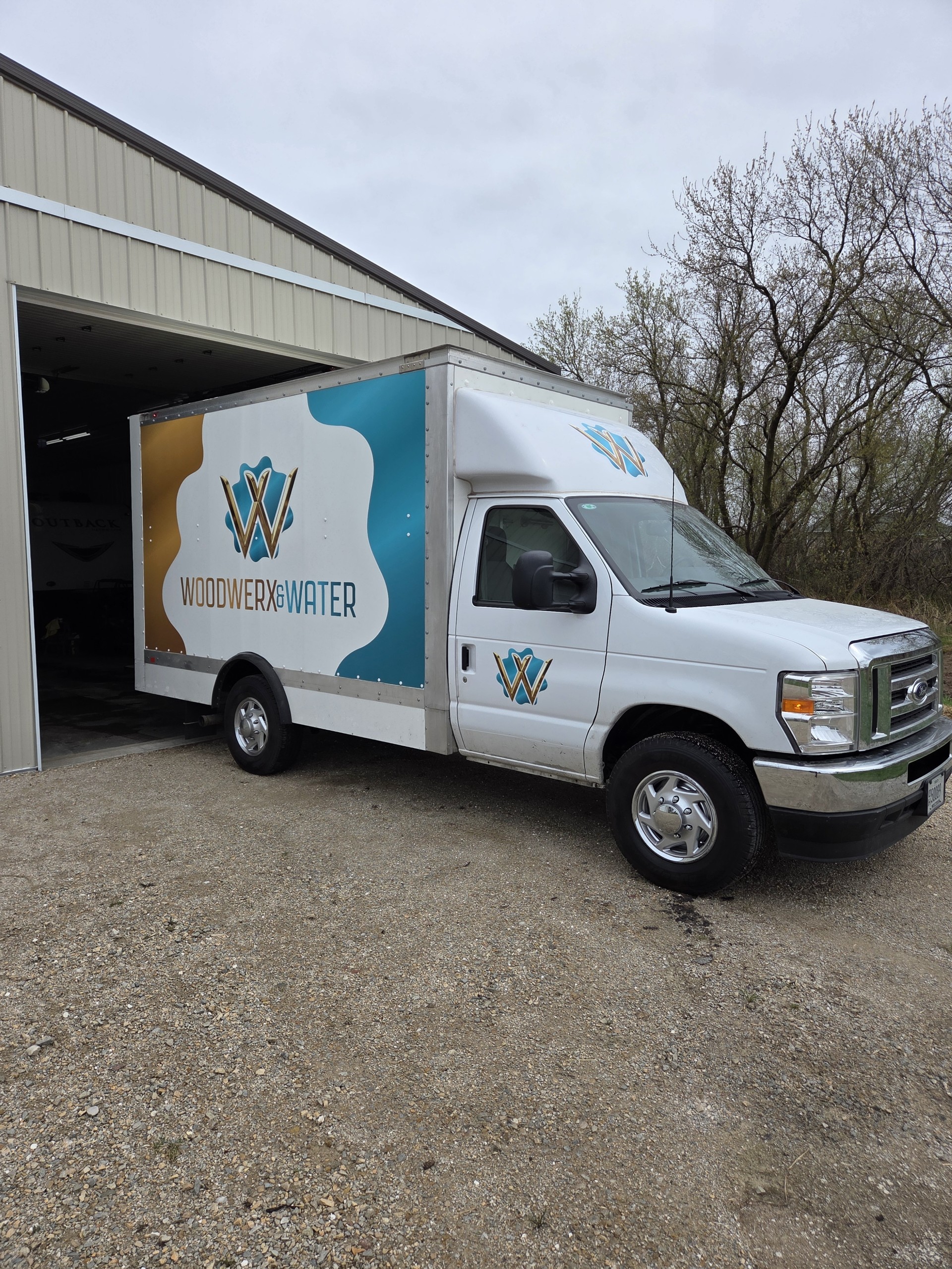 Woodwerx & Water branded work truck parked outside a shop